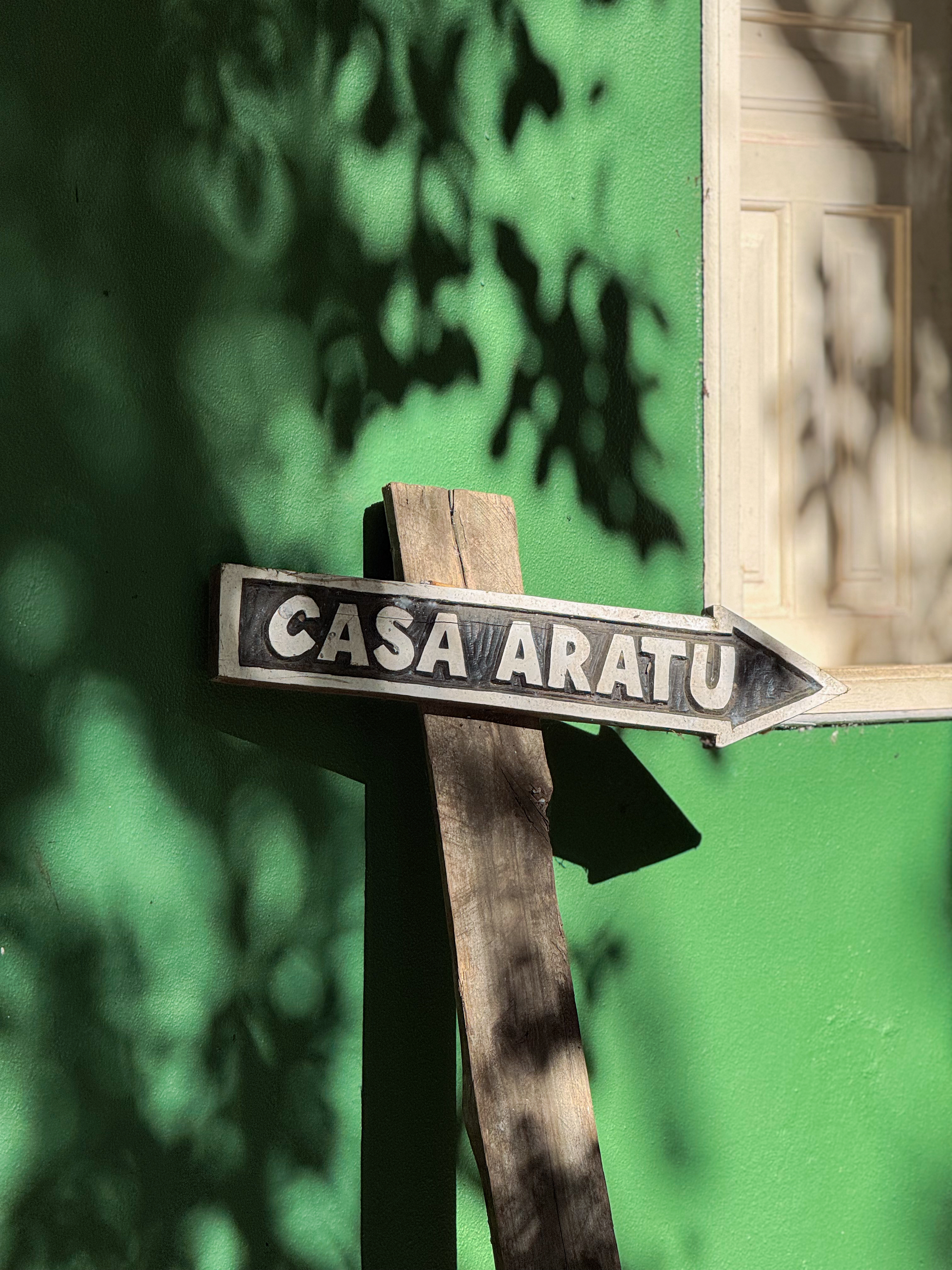 Placa Casa Aratu na parede verde