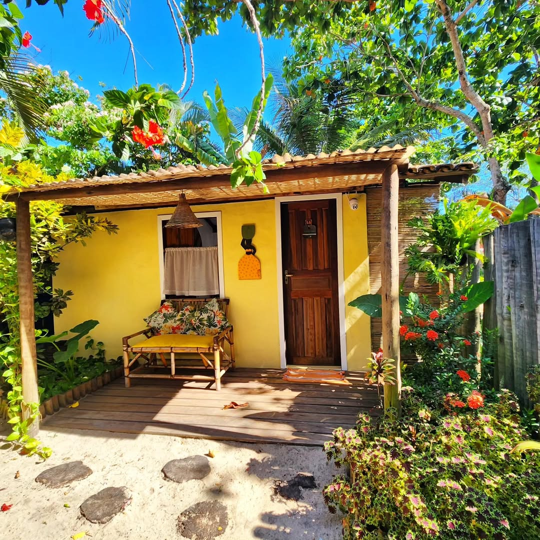Casa amarela cercada por vegetação tropical